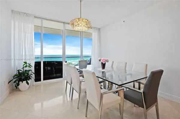 a view of a dining room with furniture and a chandelier