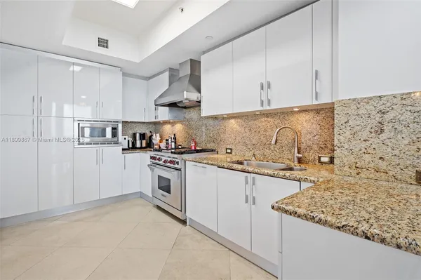 a kitchen with stainless steel appliances granite countertop a sink stove and cabinets