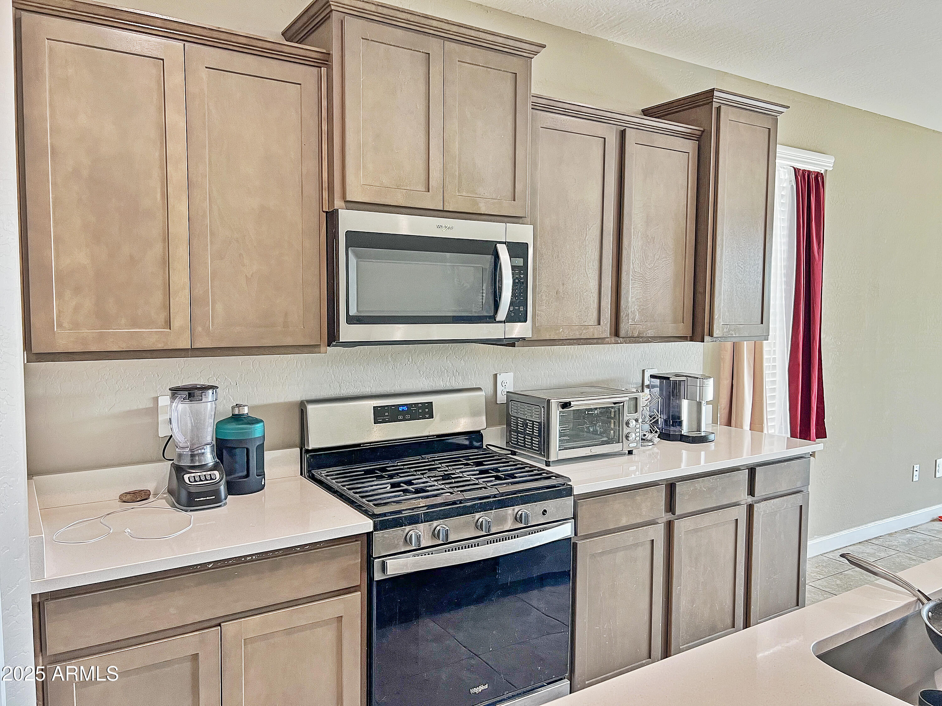 8491 West Springfield Way Florence, AZ 85132 - Photo 11 of 34 a kitchen with stainless steel appliances granite countertop a sink stove and microwave