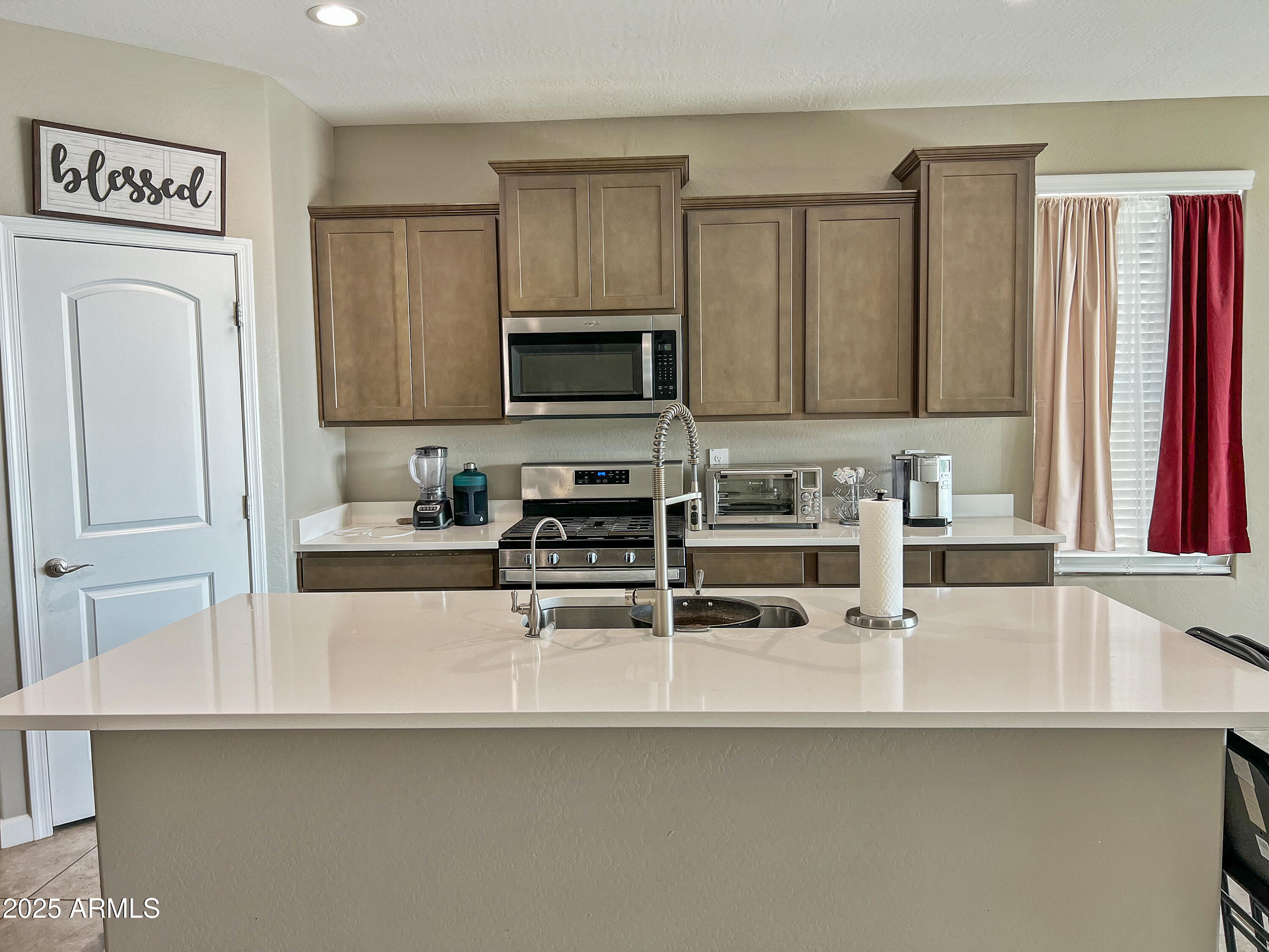 8491 West Springfield Way Florence, AZ 85132 - Photo 12 of 34 a kitchen with stainless steel appliances a sink a stove a microwave and cabinets
