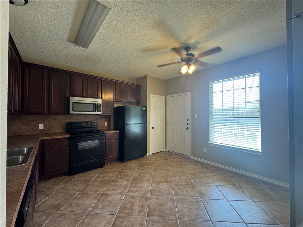 124 Sterling Street College Station, TX 77840 - Photo 4 of 13 a kitchen with granite countertop a refrigerator and a stove top oven