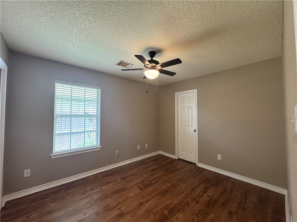124 Sterling Street College Station, TX 77840 - Photo 10 of 13 an empty room with wooden floor and ceiling fan