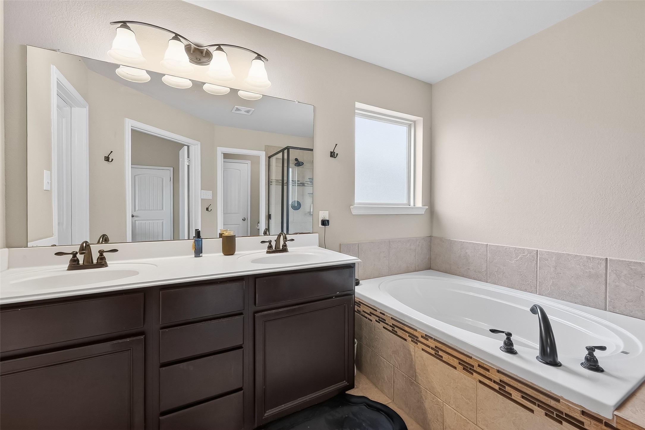 5919 Micah Lane Rosenberg, TX 77471 - Photo 25 of 39 Primary bathroom with a bright window, a separate soaking tub and generous storage that provides ample space