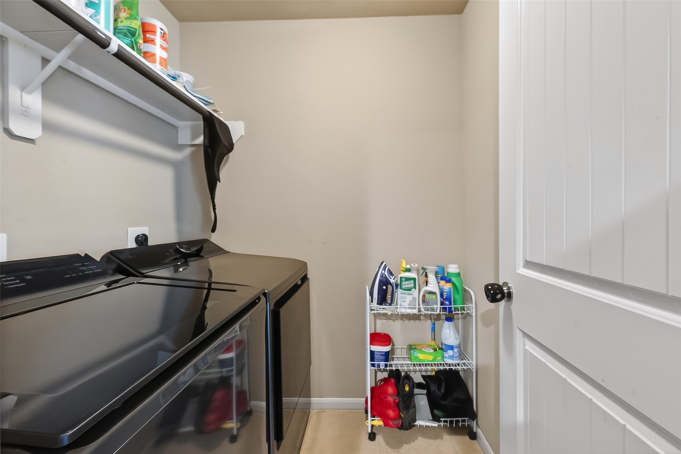 5919 Micah Lane Rosenberg, TX 77471 - Photo 34 of 39 This laundry room is designed for efficiency, featuring overhead shelving to keep everything organized. It’s a dedicated, practical area that makes daily chores a breeze