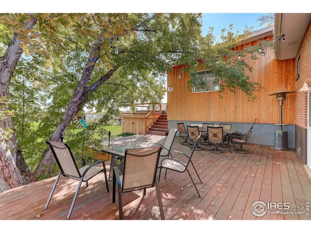 a view of a patio with table and chairs and potted plants with wooden floor