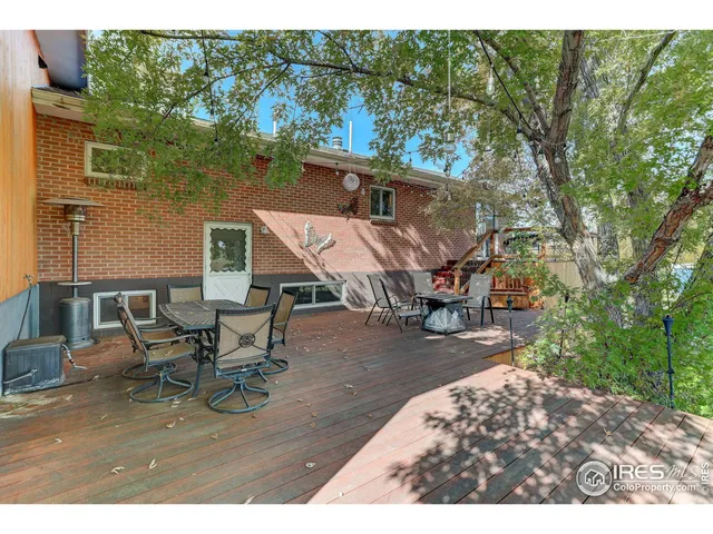 a view of a patio with table and chairs with wooden floor and fence