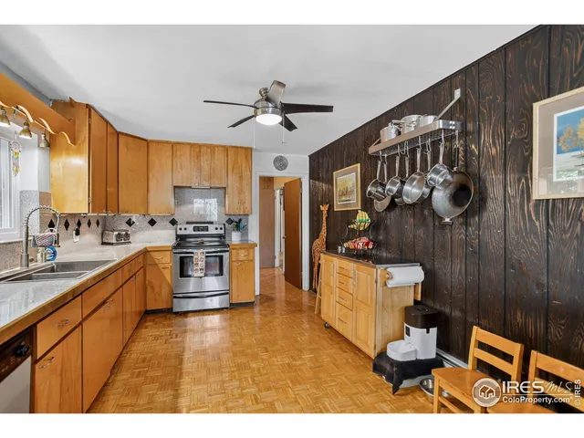 a kitchen with granite countertop wooden cabinets a stove a sink and a stainless steel appliances