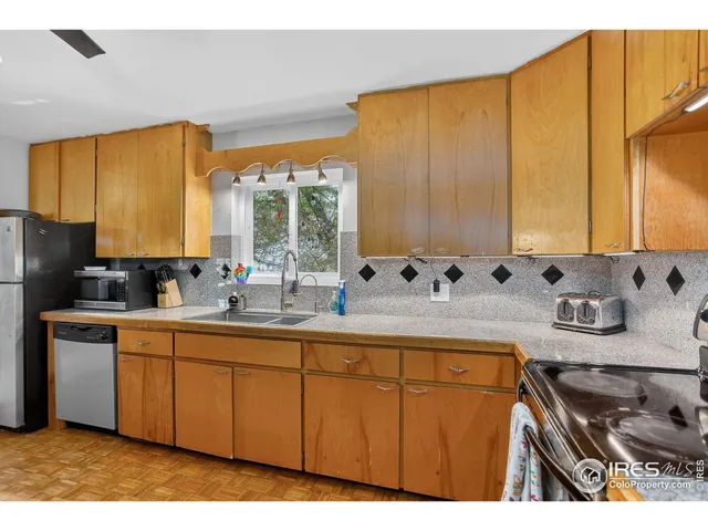 a kitchen with stainless steel appliances a sink a stove and a refrigerator