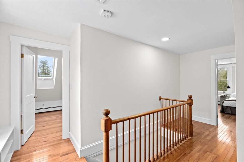 90 Brook Street Wellesley, MA 02482 - Photo 28 of 40 a view of a hallway with a dining room and wooden floor