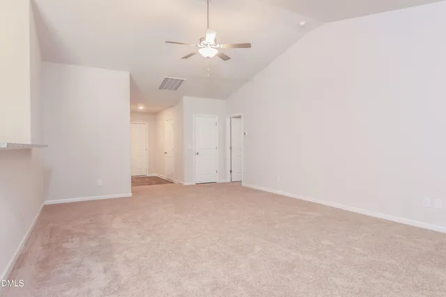 an empty room with chandelier fan
