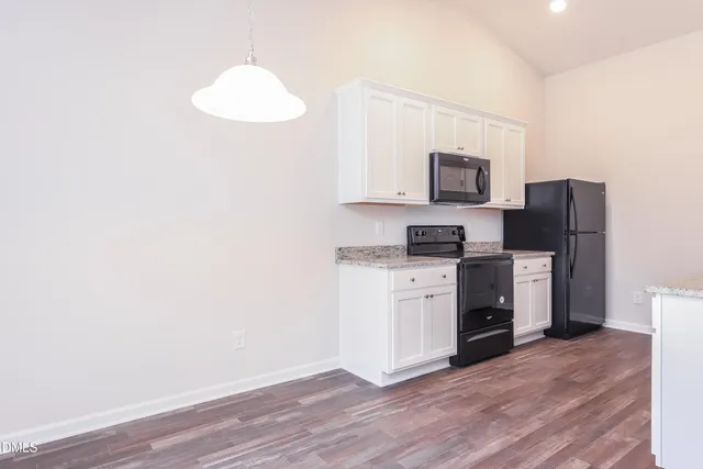 a kitchen with a refrigerator and a stove top oven
