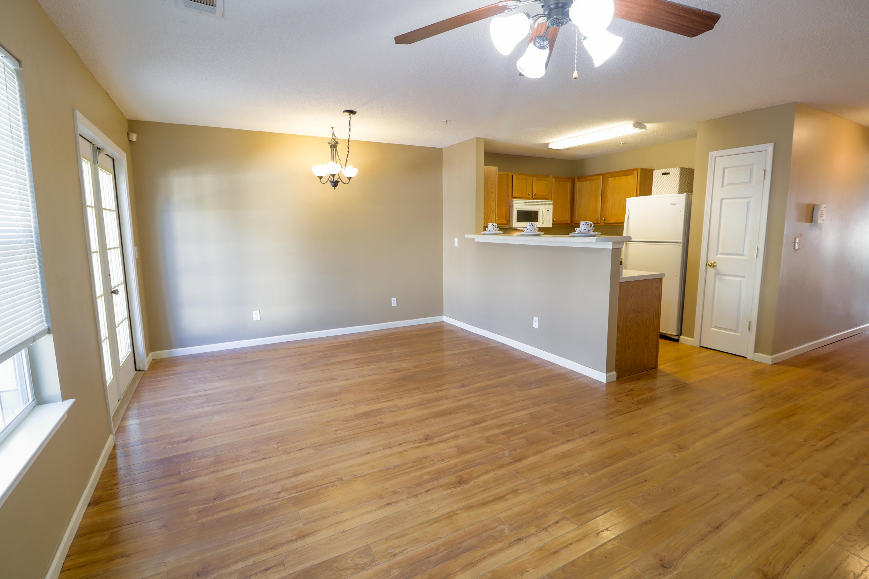 406 Crooked Pine Trail Crestview, FL 32539 - Photo 5 of 22 a view of a kitchen with a refrigerator a ceiling fan and wooden floor