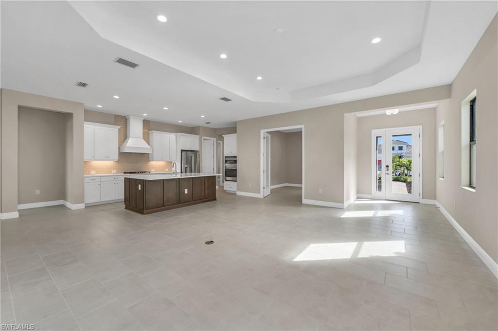 3993 Perseus Street Naples, FL 34120 - Photo 20 of 20 Kitchen featuring open floor plan, white cabinetry, a center island with sink, custom exhaust hood, and recessed lighting