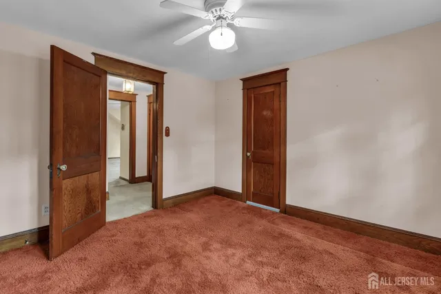 an empty room with windows and ceiling fan