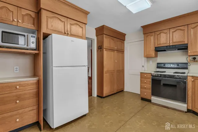 a kitchen with stainless steel appliances granite countertop a refrigerator and a stove