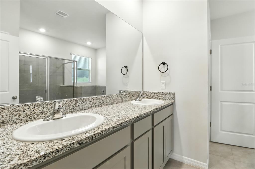 8931 Southwest 49th Circle Ocala, FL 34476 - Photo 14 of 42 a bathroom with a granite countertop sink and a mirror