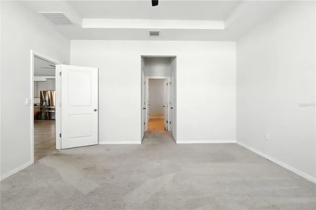 an empty room with a window and a ceiling fan