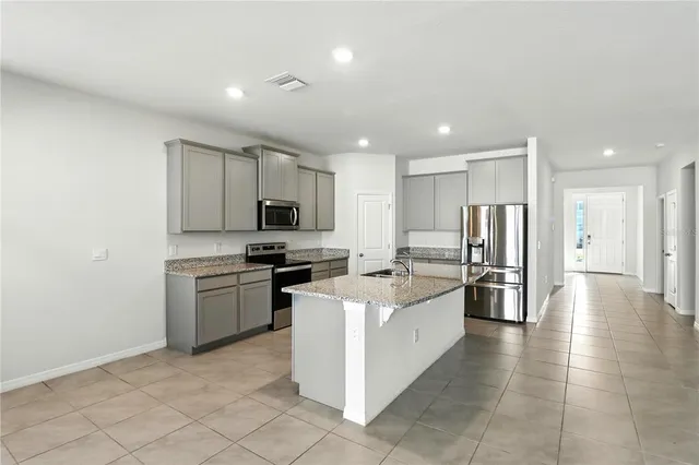 a view of a kitchen with a sink refrigerator and window