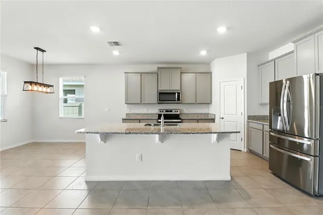 a kitchen with stainless steel appliances granite countertop a refrigerator and a sink