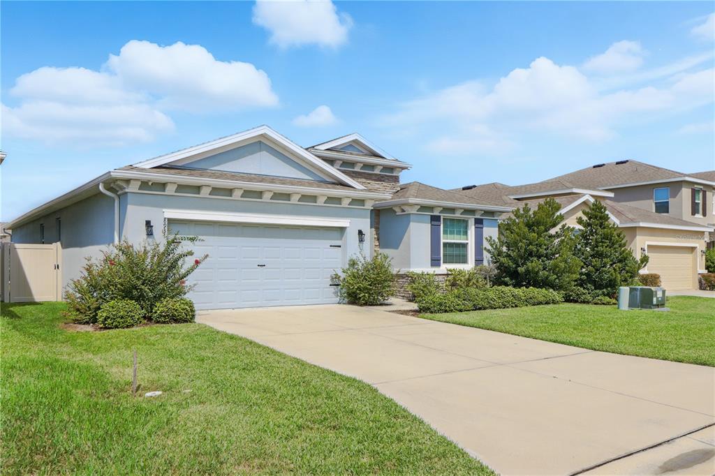 8931 Southwest 49th Circle Ocala, FL 34476 - Photo 40 of 42 a front view of a house with a yard and garage
