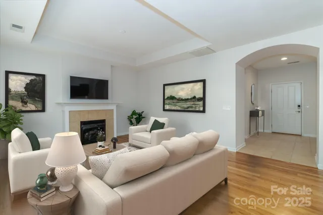 a kitchen with stainless steel appliances granite countertop a sink a stove a refrigerator a kitchen island a stove and a wooden floors