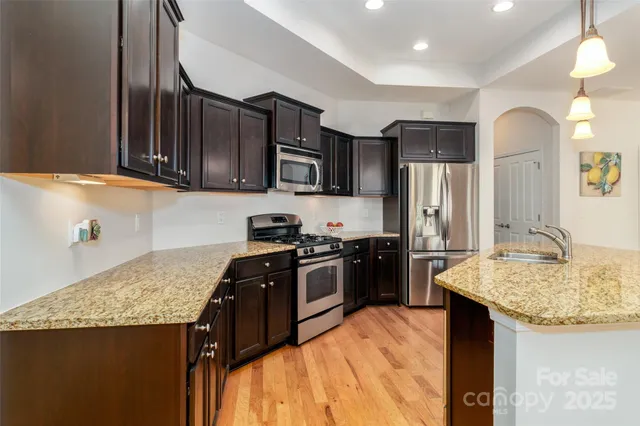 a dining room with furniture a chandelier and wooden floor