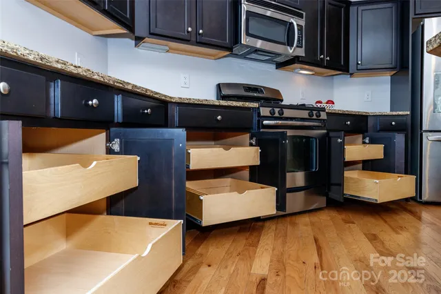 a view of a kitchen with a sink stainless steel appliances and chandelier