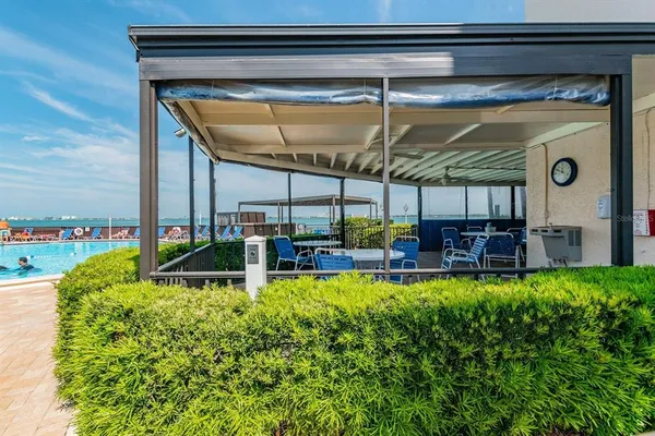 a view of a patio with table and chairs potted plants and a lake view