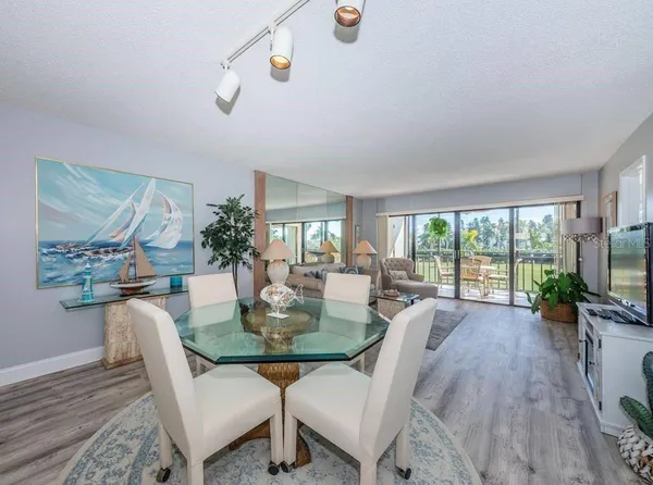 a dining room with furniture a chandelier and wooden floor