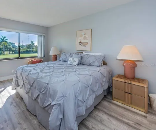 a large bed sitting in a bedroom next to a window