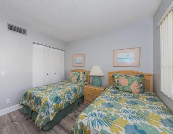 a bedroom with two beds and a lamp