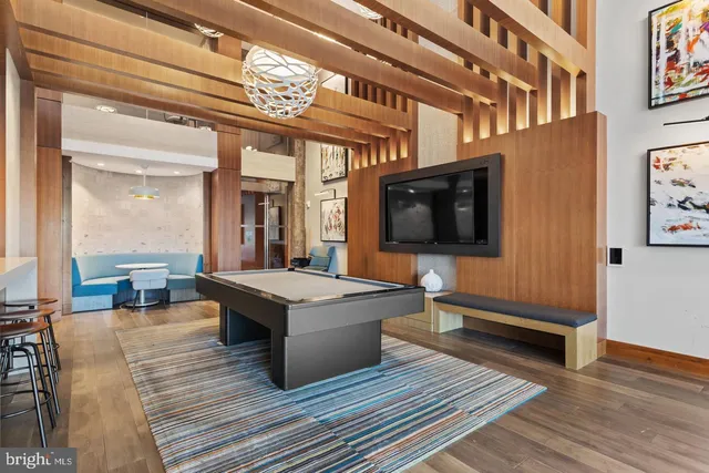 a living room with a table chairs flat screen tv and outdoor view