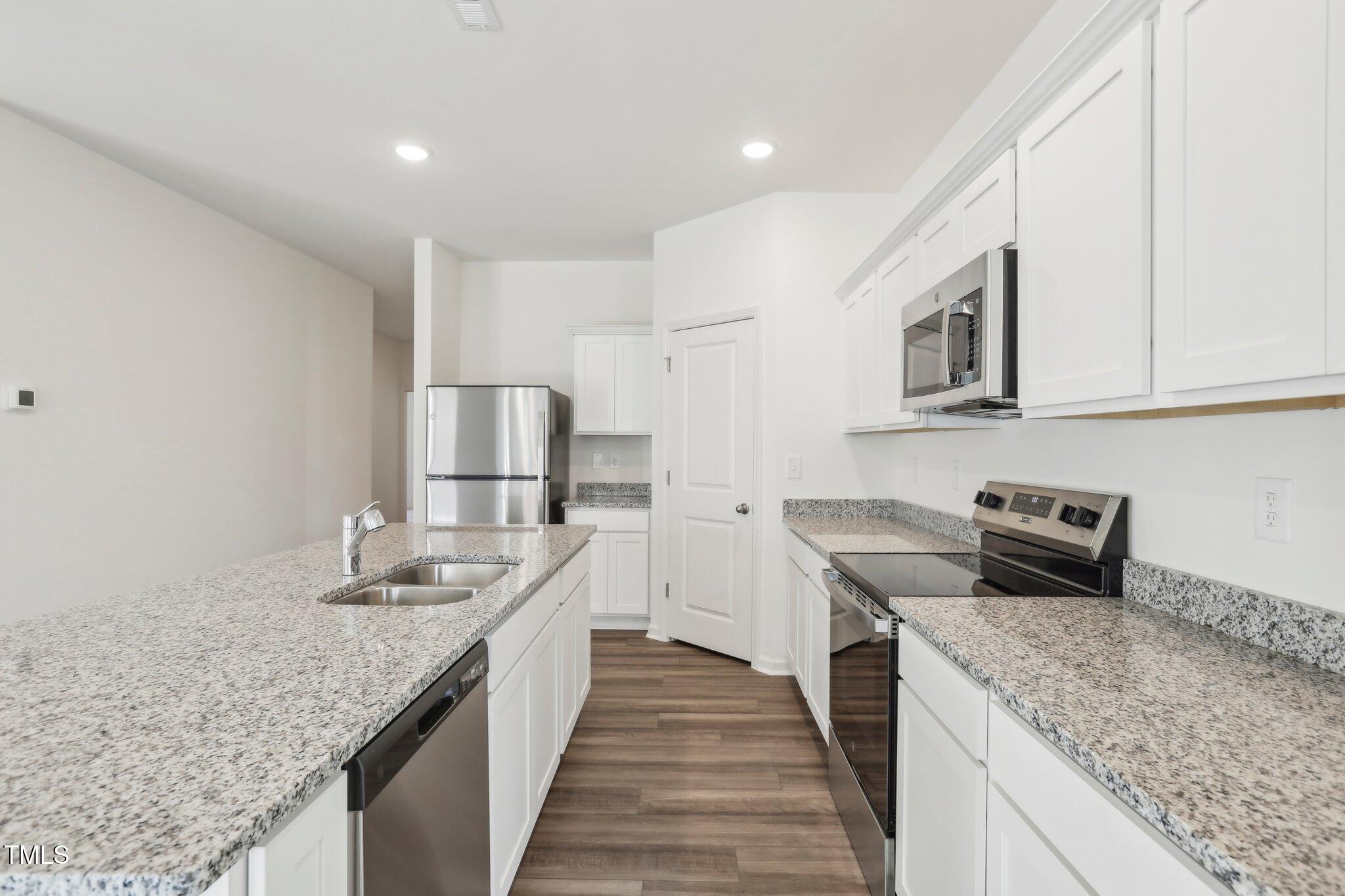 927 Embraer Way Spring Hope, NC 27882 - Photo 33 of 43 a kitchen with stainless steel appliances granite countertop a sink stove and refrigerator