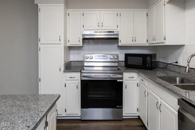 a kitchen with stainless steel appliances granite countertop a refrigerator sink and cabinets