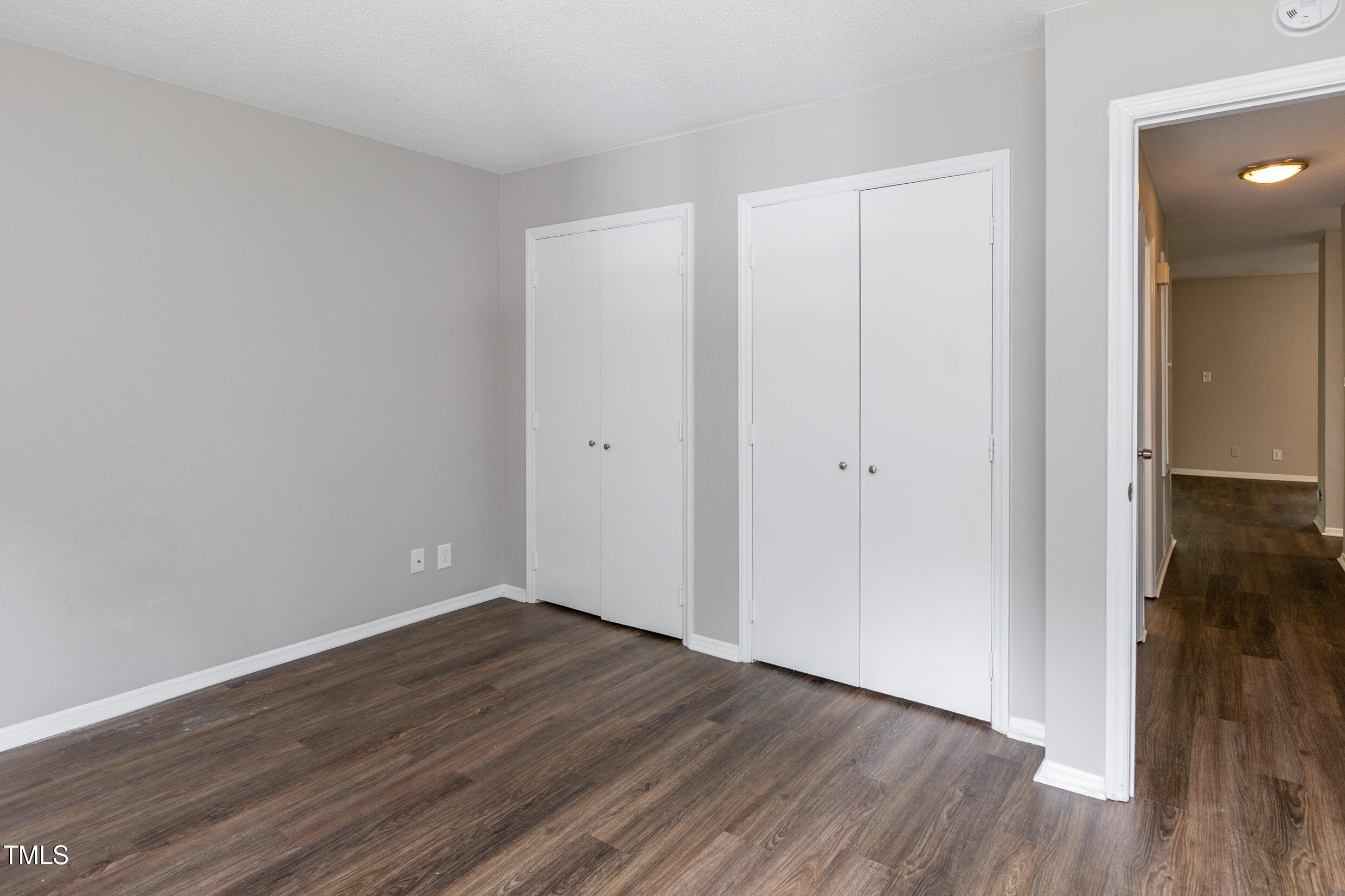 5036 Flint Ridge Place Raleigh, NC 27609 - Photo 19 of 21 a view of an empty room with wooden floor and a bathroom