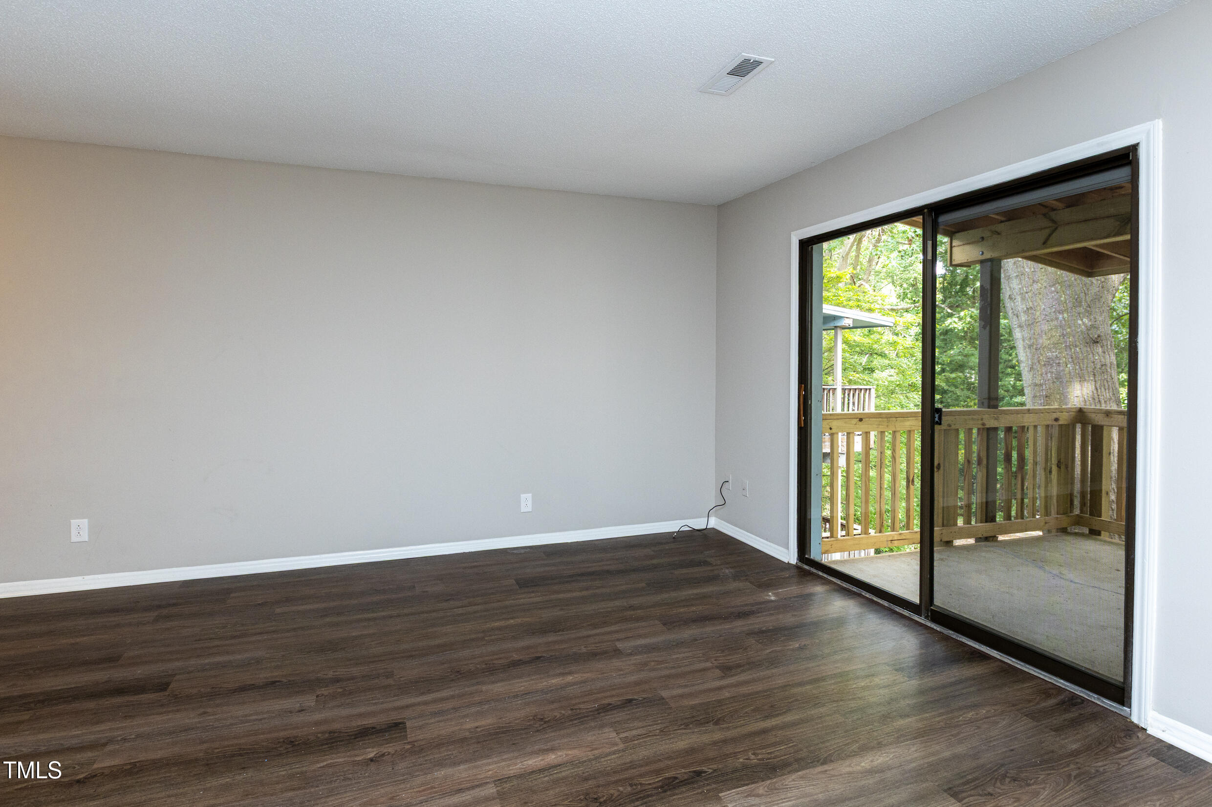 5036 Flint Ridge Place Raleigh, NC 27609 - Photo 6 of 21 a view of an empty room with wooden floor and a window