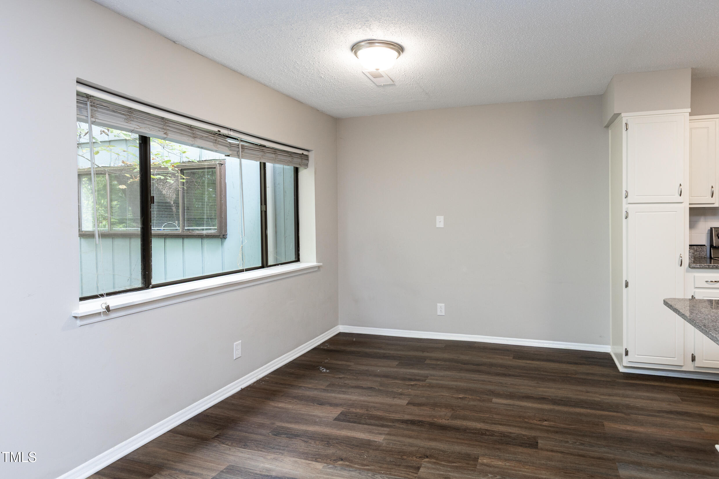 5036 Flint Ridge Place Raleigh, NC 27609 - Photo 8 of 21 a view of an empty room with wooden floor and a window