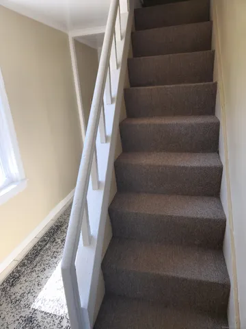 a view of staircase with white walls and a window