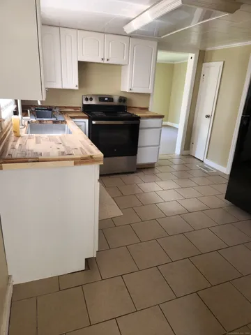 a kitchen with granite countertop a sink and a stove top oven