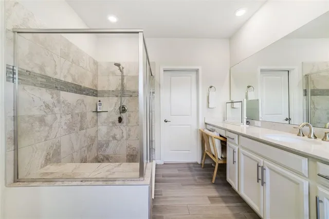a bathroom with a double vanity sink mirror and shower