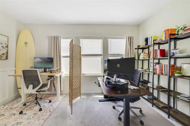 a view of a workspace with furniture and a window