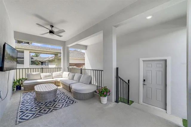 a living room with furniture a large window and wooden floor