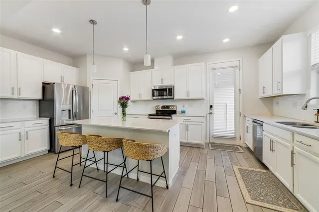 a kitchen with white cabinets stainless steel appliances and a center island