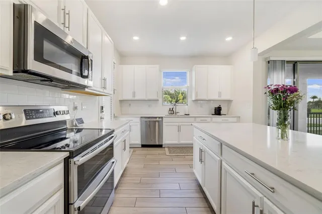 a kitchen with stainless steel appliances granite countertop a sink stove and microwave