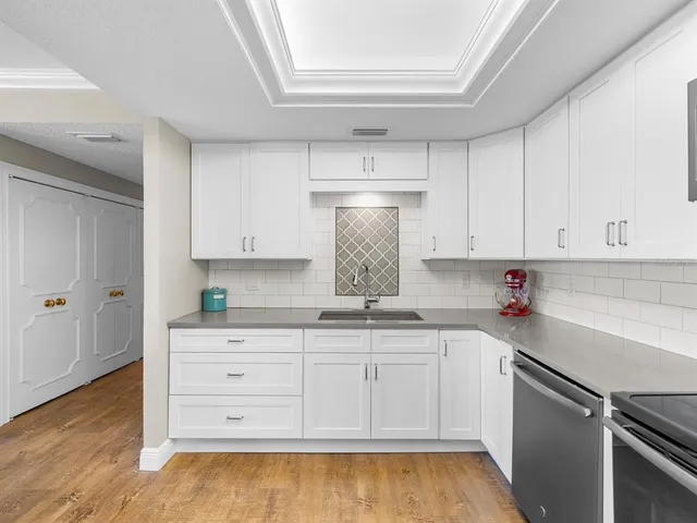 a kitchen with granite countertop white cabinets and white appliances