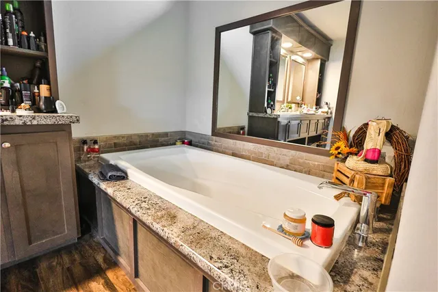 a bathroom with a granite countertop sink and a mirror