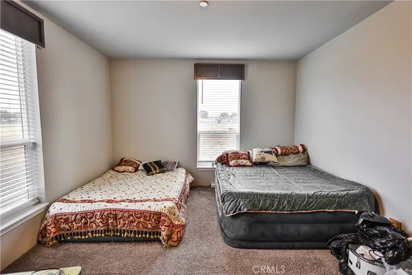 a bedroom with two beds and a dresser