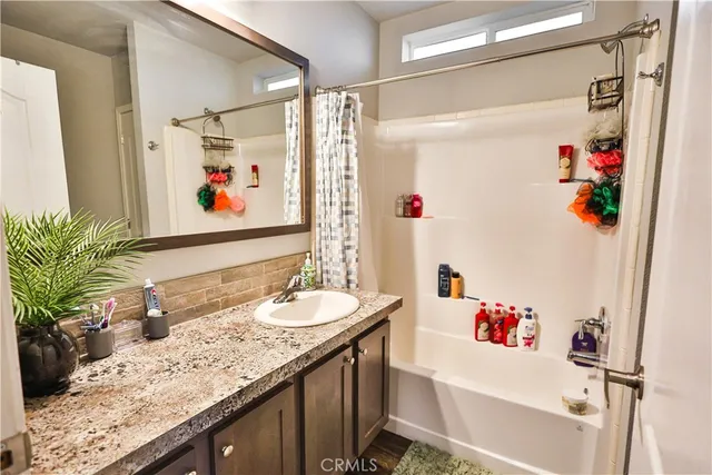 a bathroom with a granite countertop sink a large mirror and a shower