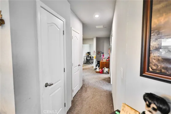 a view of a hallway to a livingroom with furniture