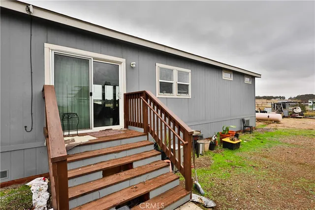 a backyard of a house with wooden floor and outdoor seating